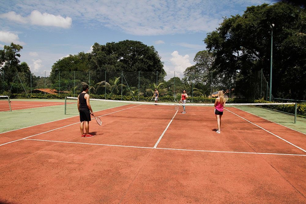 Um grupo de pessoas está jogando tênis em uma quadra de tênis.