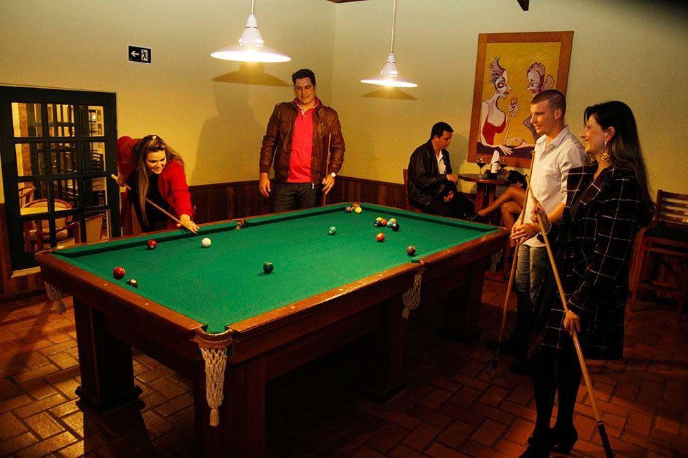 Um grupo de pessoas está jogando sinuca em uma sala