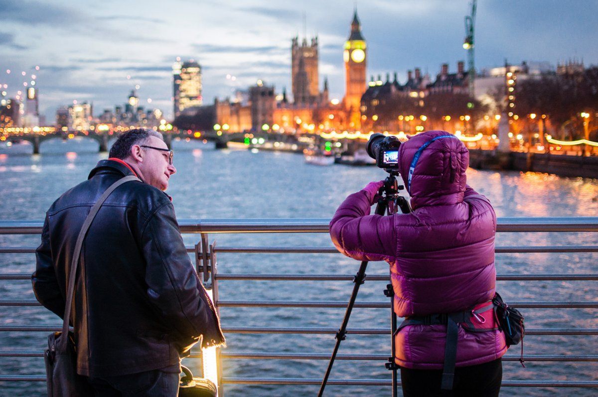 To personer fotograferer Londons skyline i skumringen; Big Ben i baggrunden.