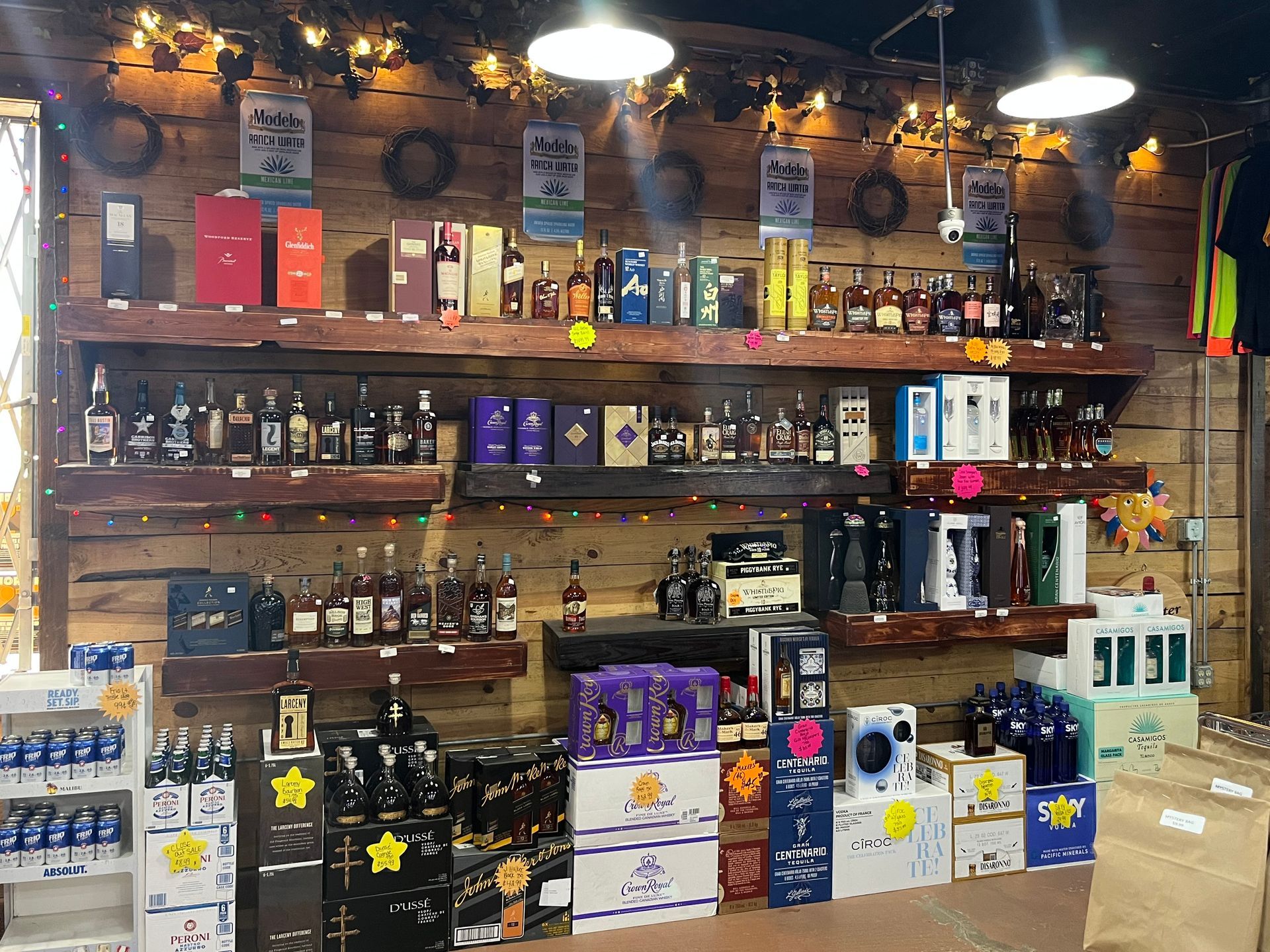 Shelves stocked with various liquor bottles in a store, set against a wooden wall.
