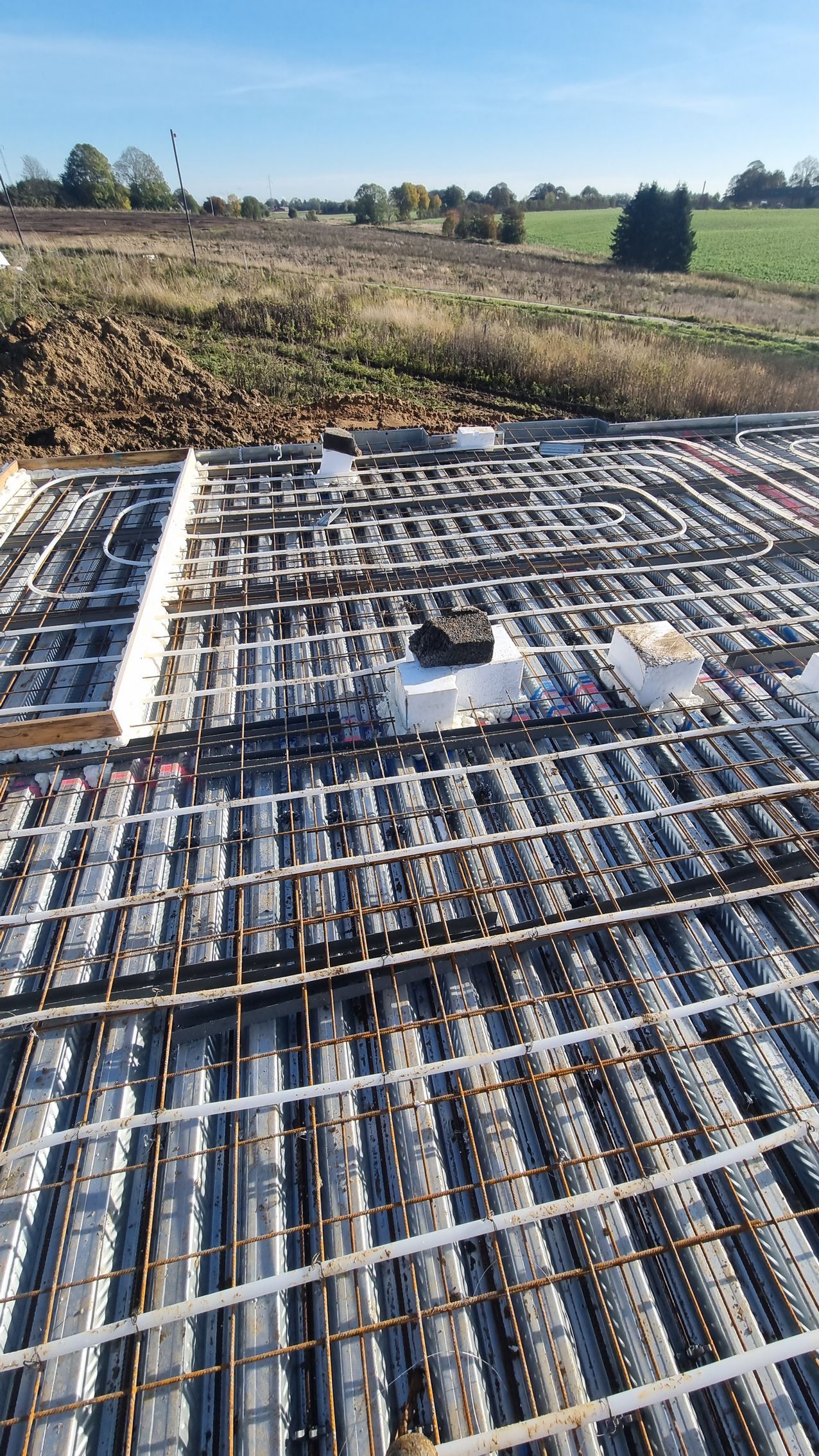 Et nærbillede af et betongulv med en mark i baggrunden.