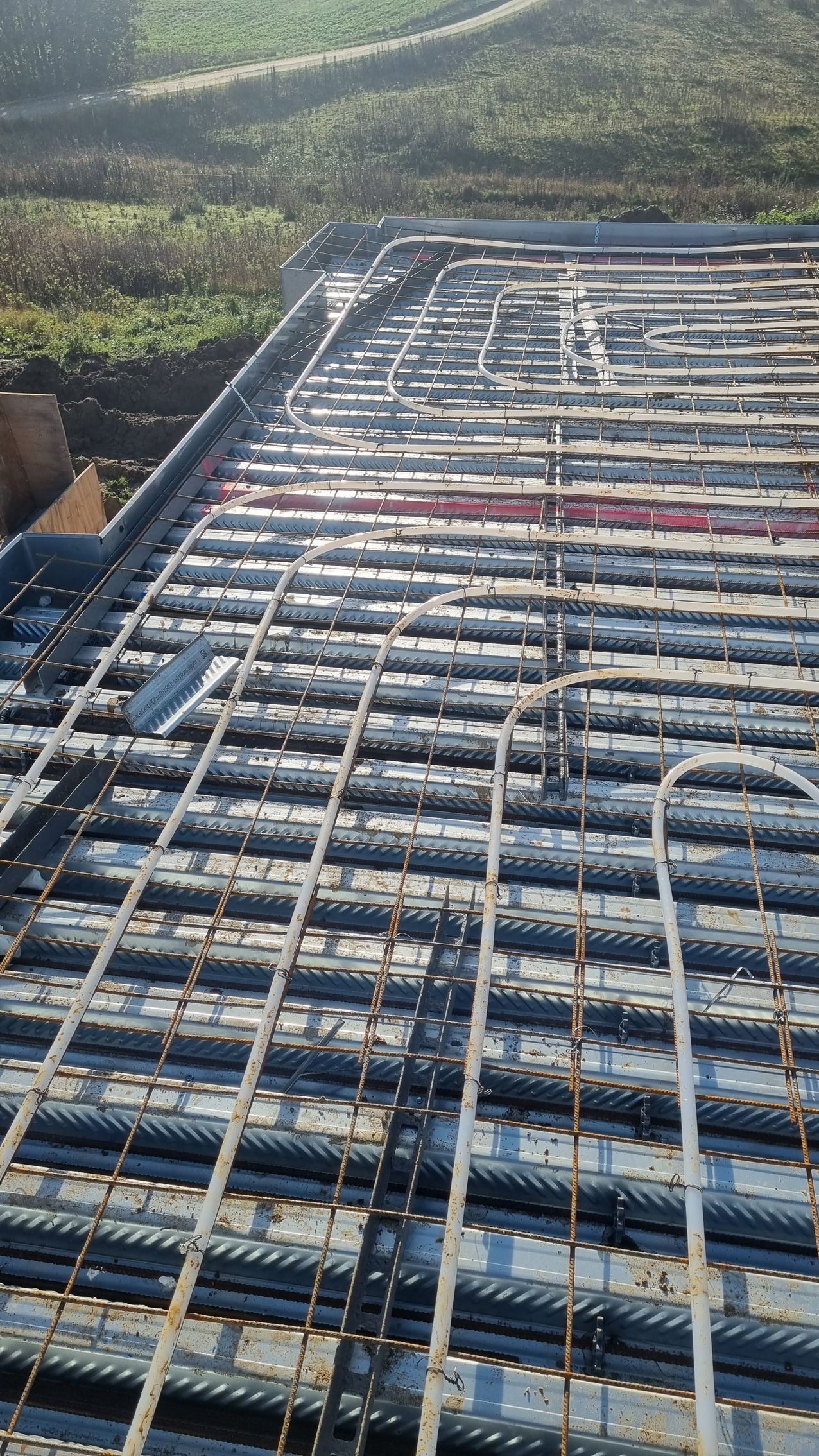 Et nærbillede af et betongulv med ledninger ført igennem det.