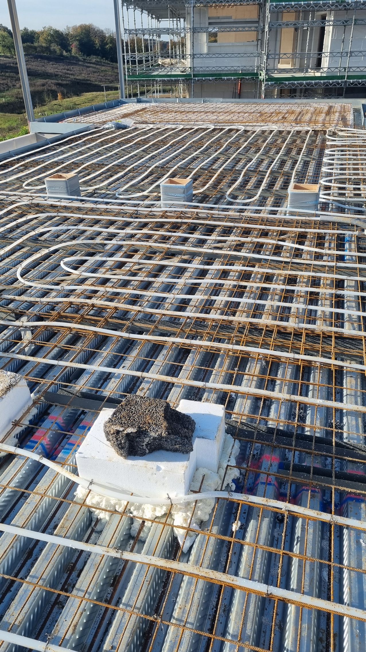 Der bygges et tag på en byggeplads med en masse ledninger.