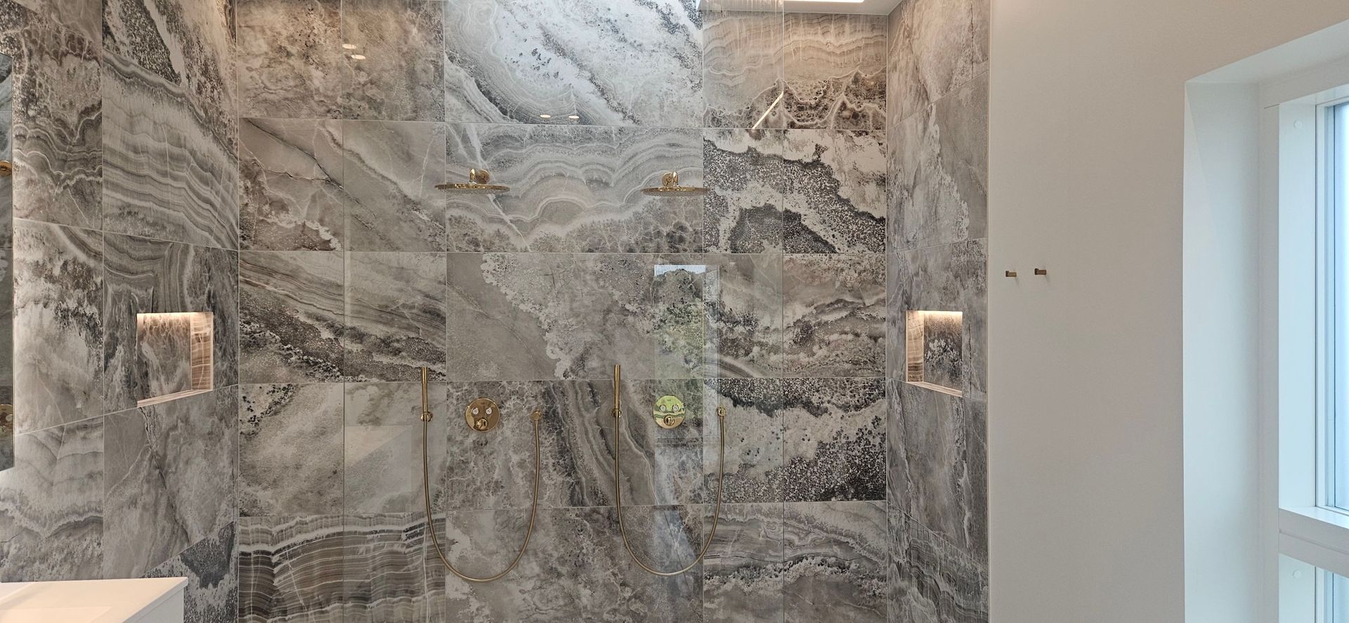 Et badeværelse med bruseniche og et vindue.