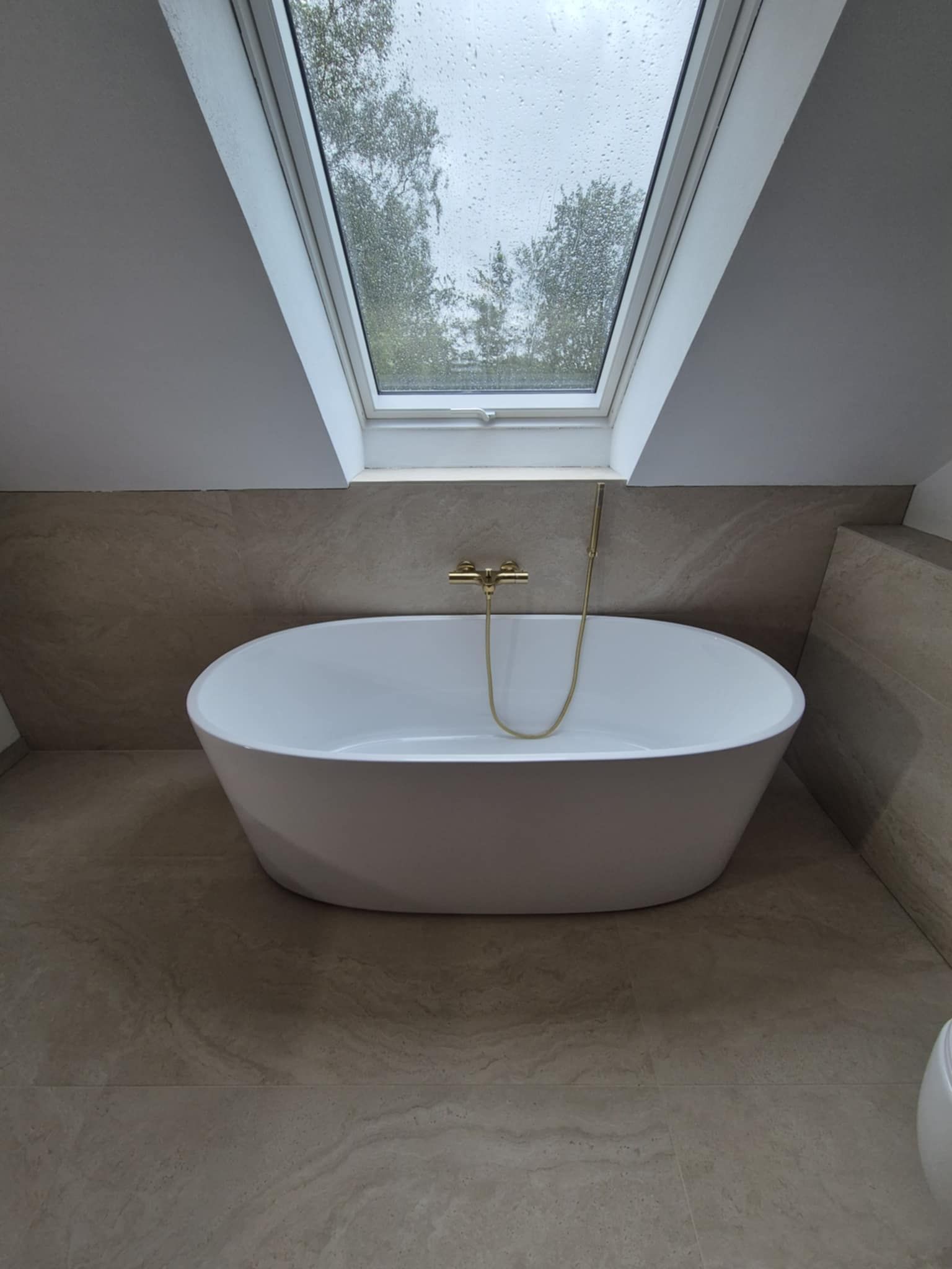 Et badekar i et badeværelse med ovenlysvindue over det