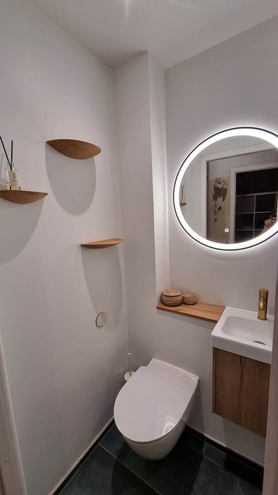 Et badeværelse med toilet, håndvask og spejl.