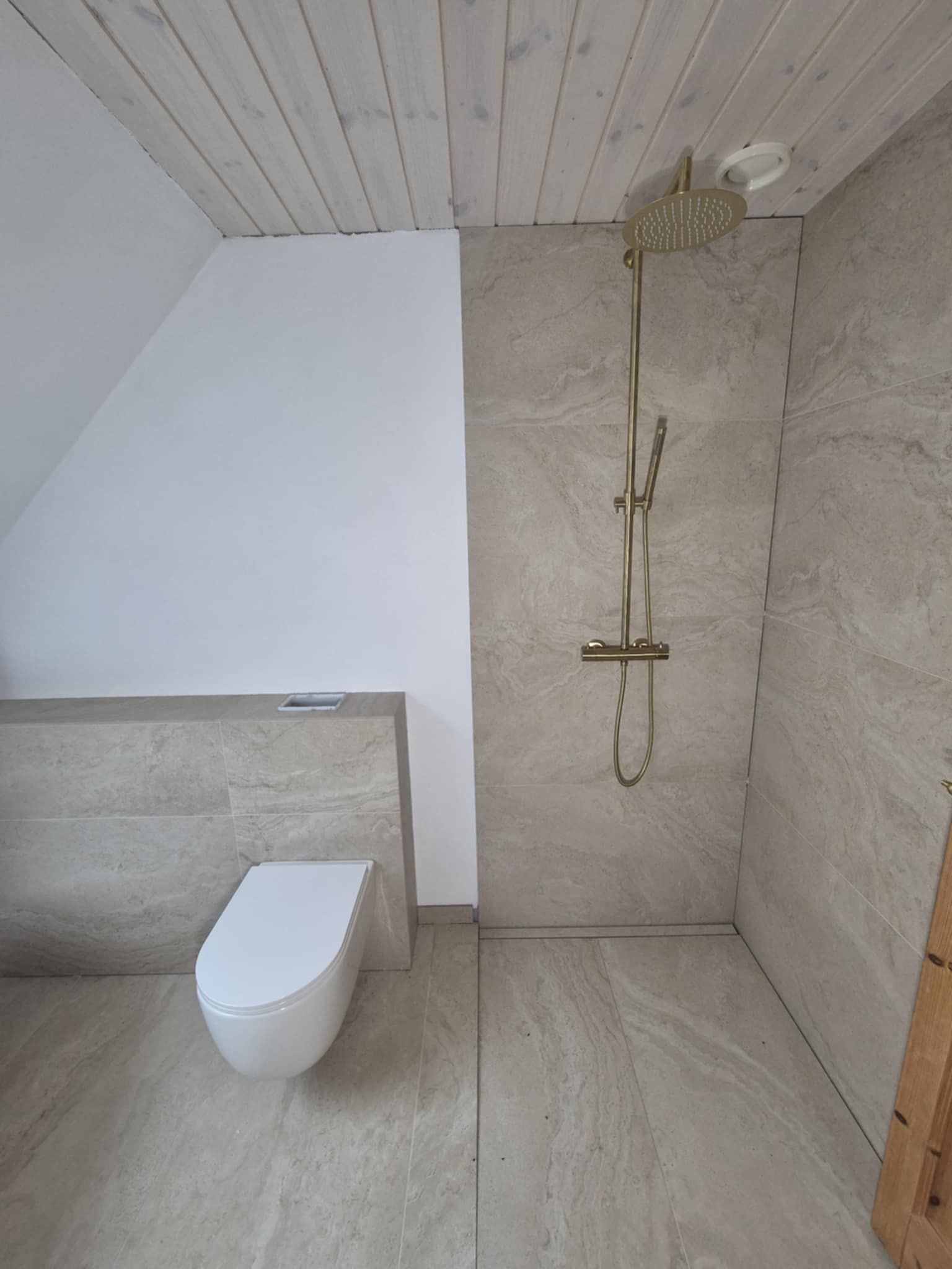 Et badeværelse med toilet og bruser.