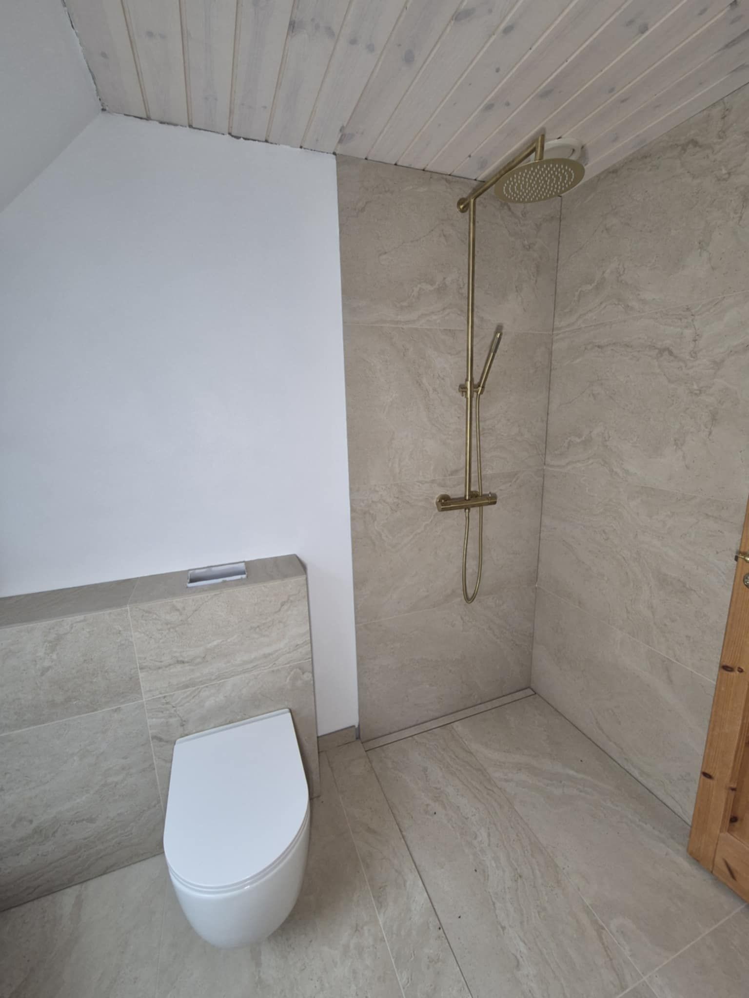 Et badeværelse med toilet og brusehoved.