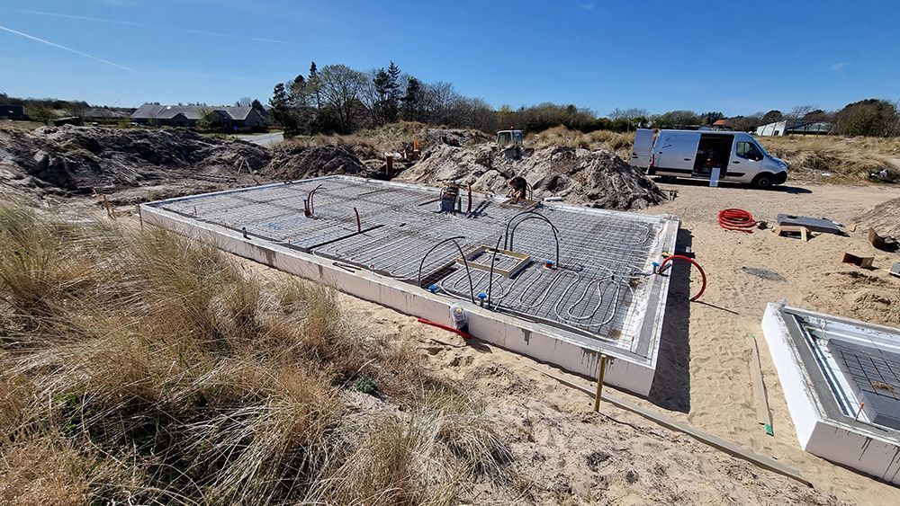 En byggeplads med en varevogn parkeret i baggrunden.