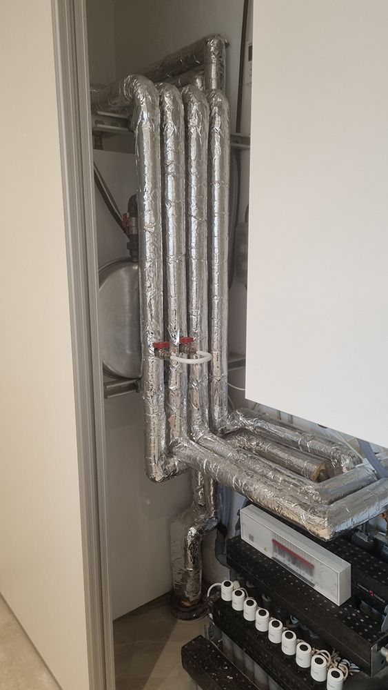 Et rum med mange rør og en hvid væg.