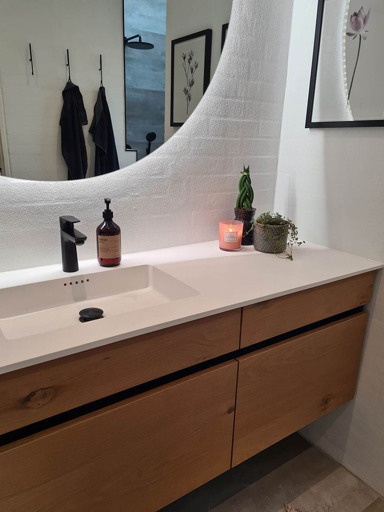 Et badeværelse med håndvask og stort spejl