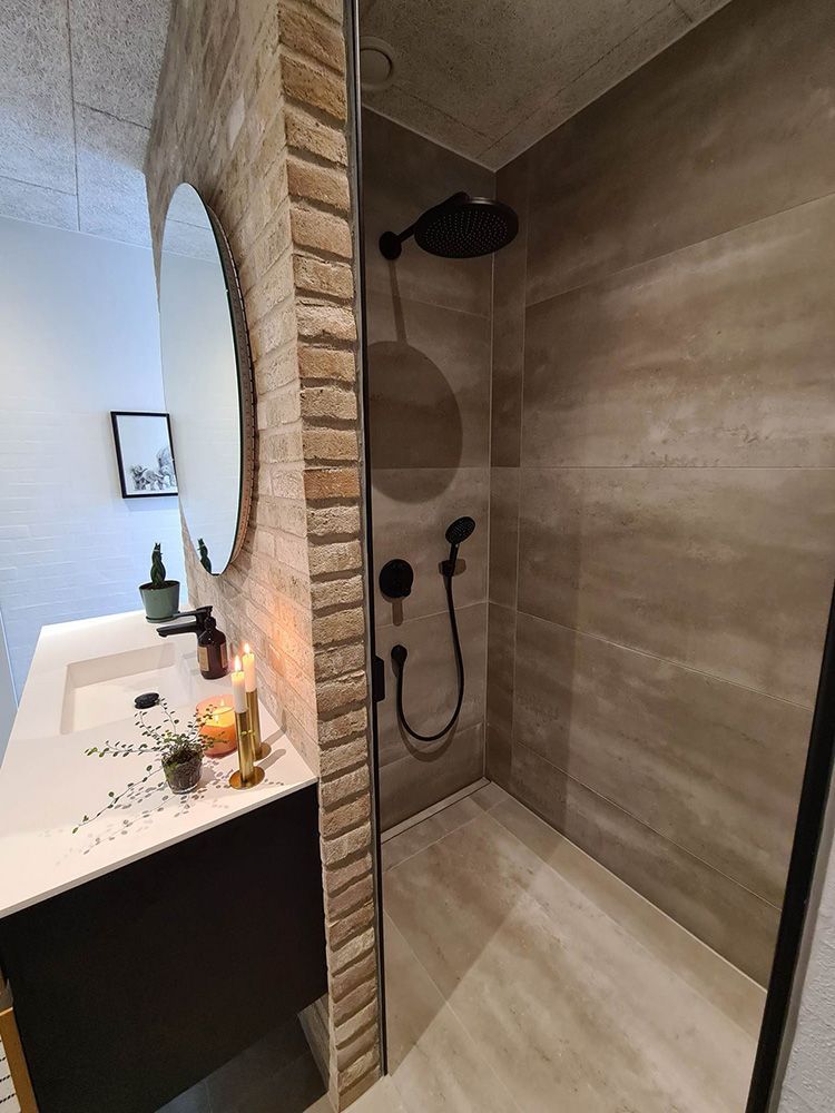 Et badeværelse med håndvask og bruseniche.