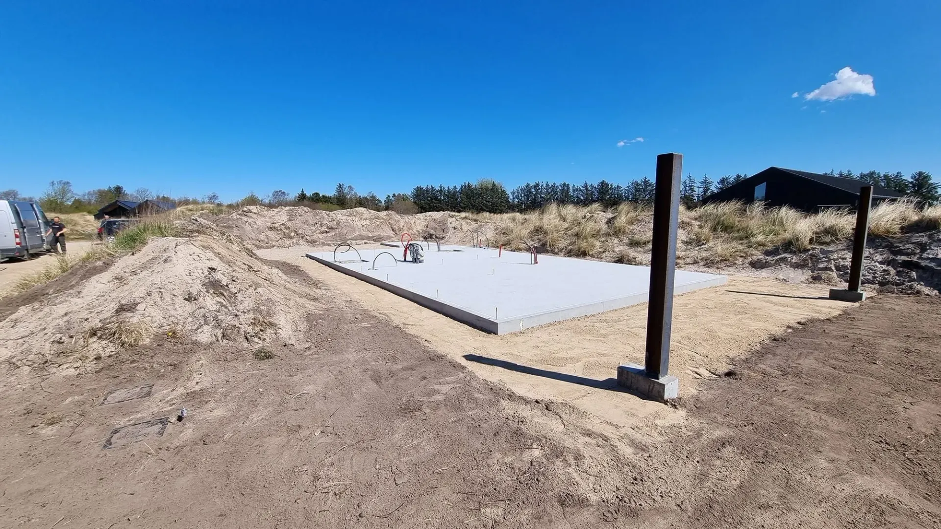 En stor betonplade står midt på en jordmark.