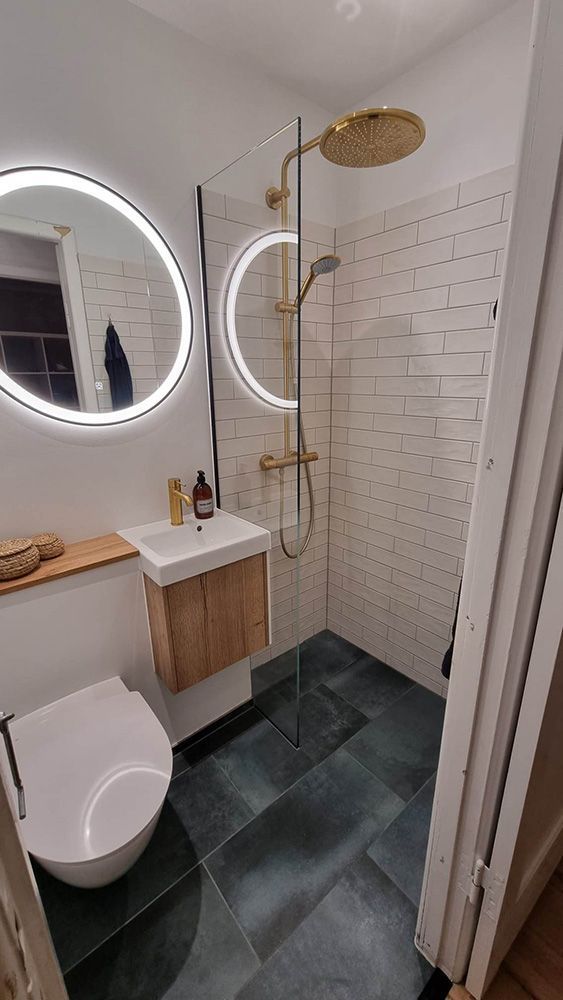 Et badeværelse med toilet, håndvask, bruser og spejl.