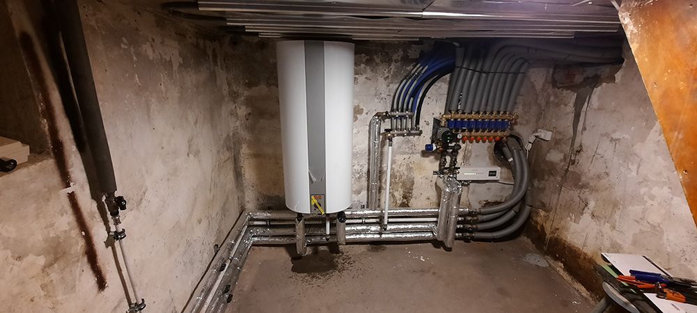 Et rum med en masse rør og ledninger hængende fra loftet.