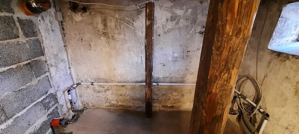 En cykel er parkeret i en kælder ved siden af ​​en træstolpe.