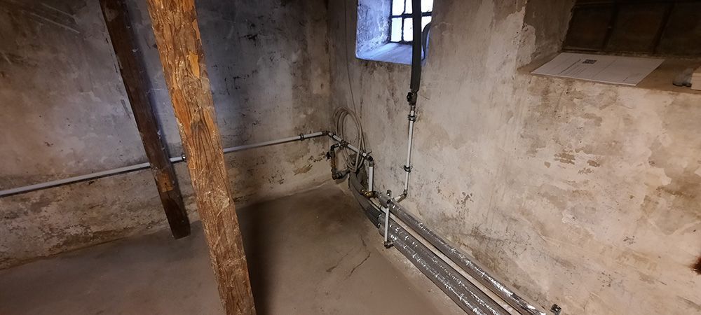 Et rum med vindue og rør på væggen.