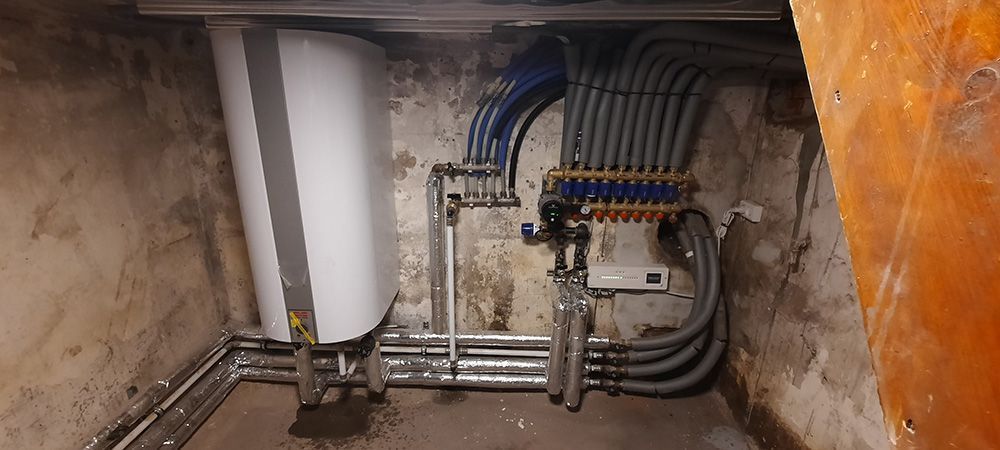 En flok rør er forbundet til en væg i et rum.