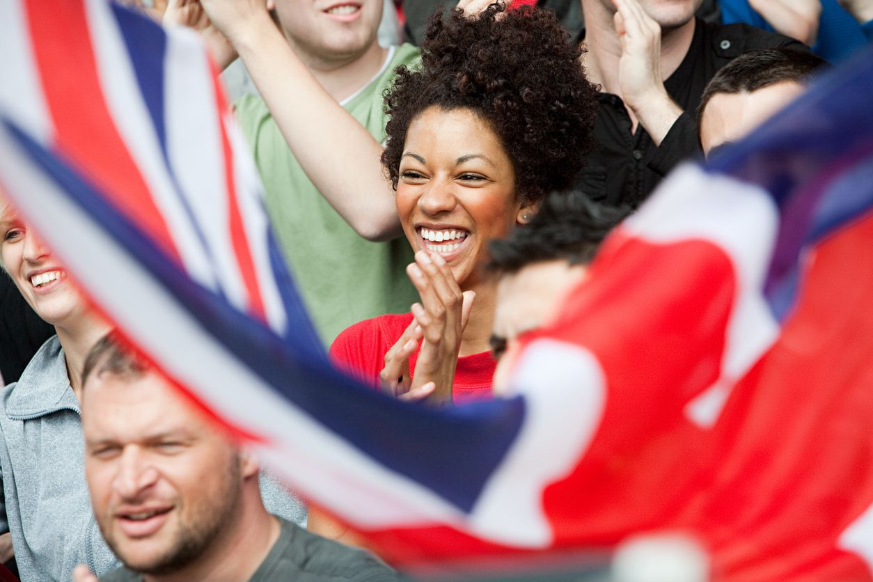 a woman is holding an american flag in front of a crowd of people .