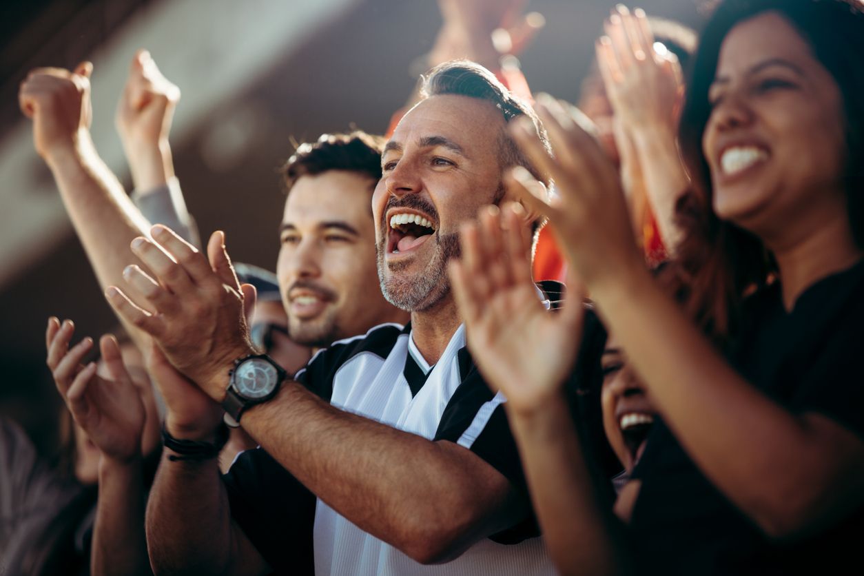 a group of people are applauding in a stadium .