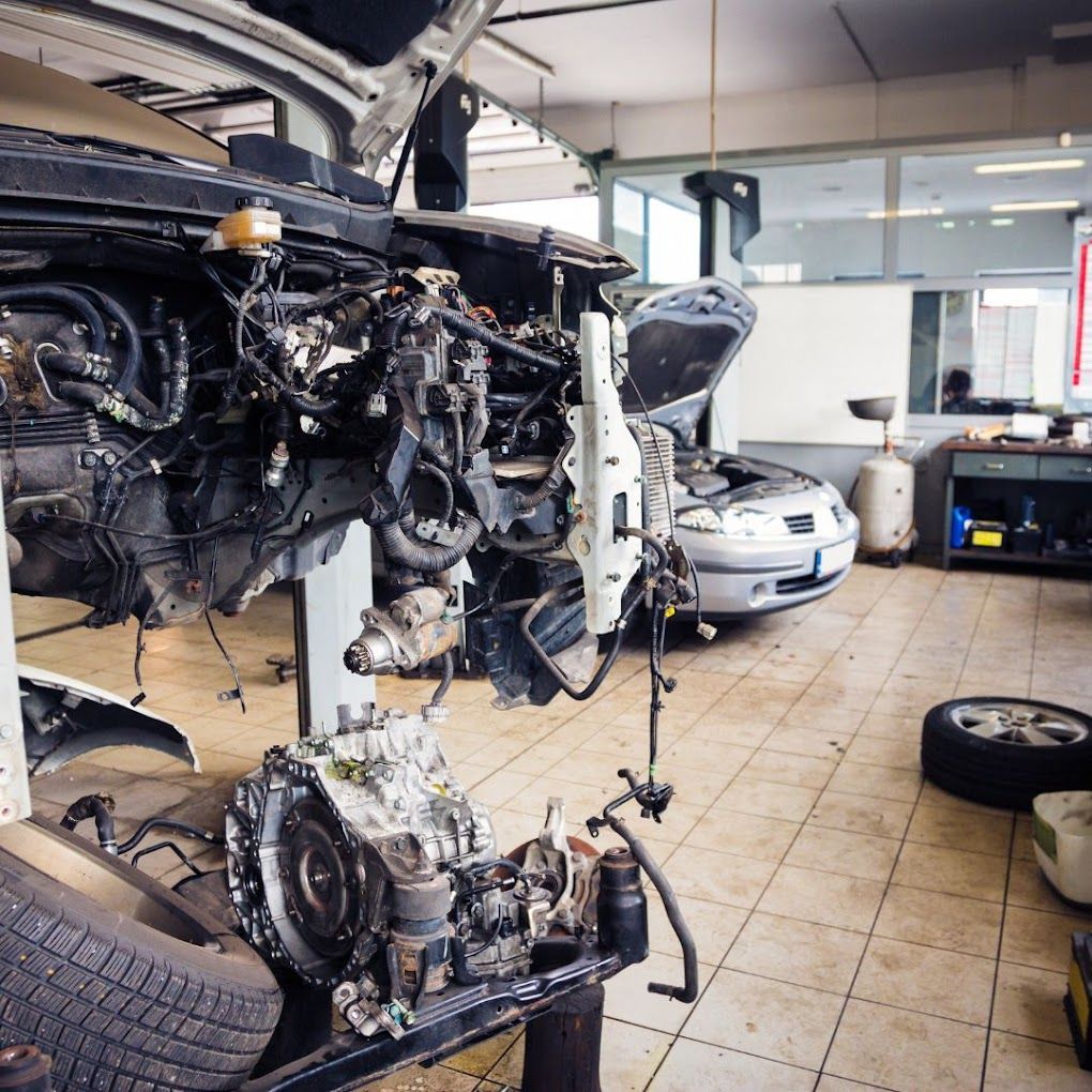 A car engine is being disassembled in a garage