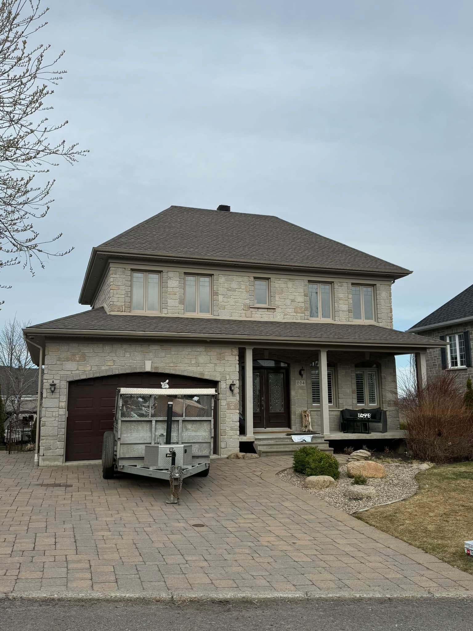 Une grande maison avec une caravane garée devant.
