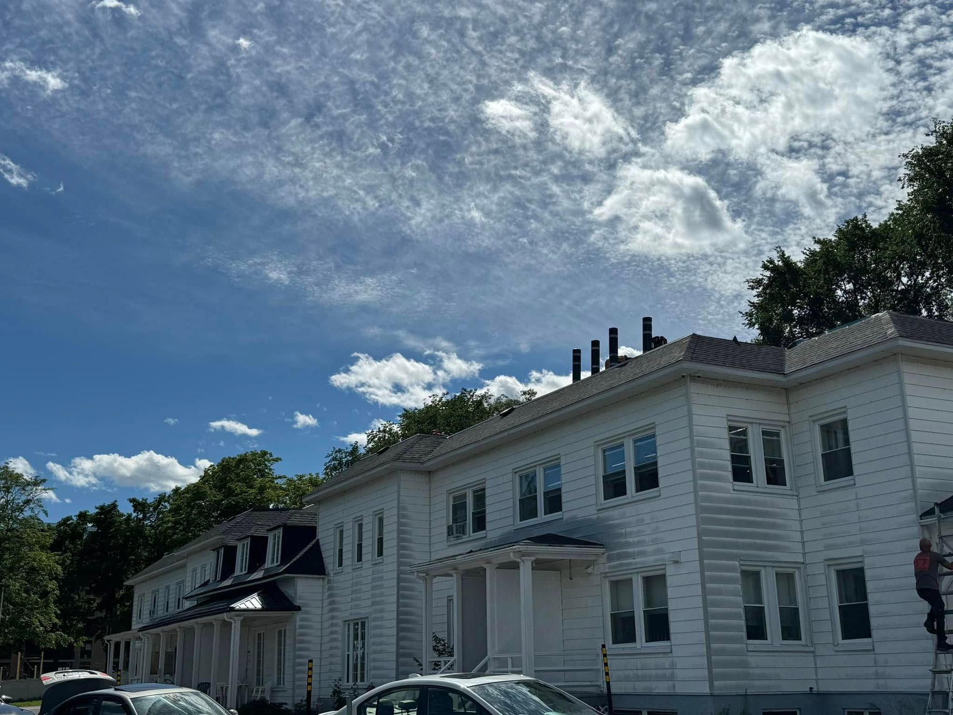 Un grand bâtiment blanc avec des voitures garées devant