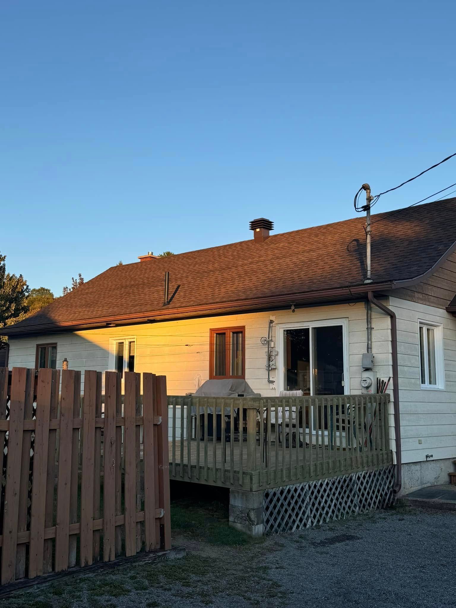 Une maison blanche avec une clôture en bois devant.