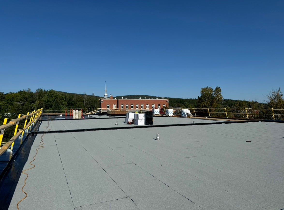 Un toit avec un bâtiment en arrière-plan et un ciel bleu