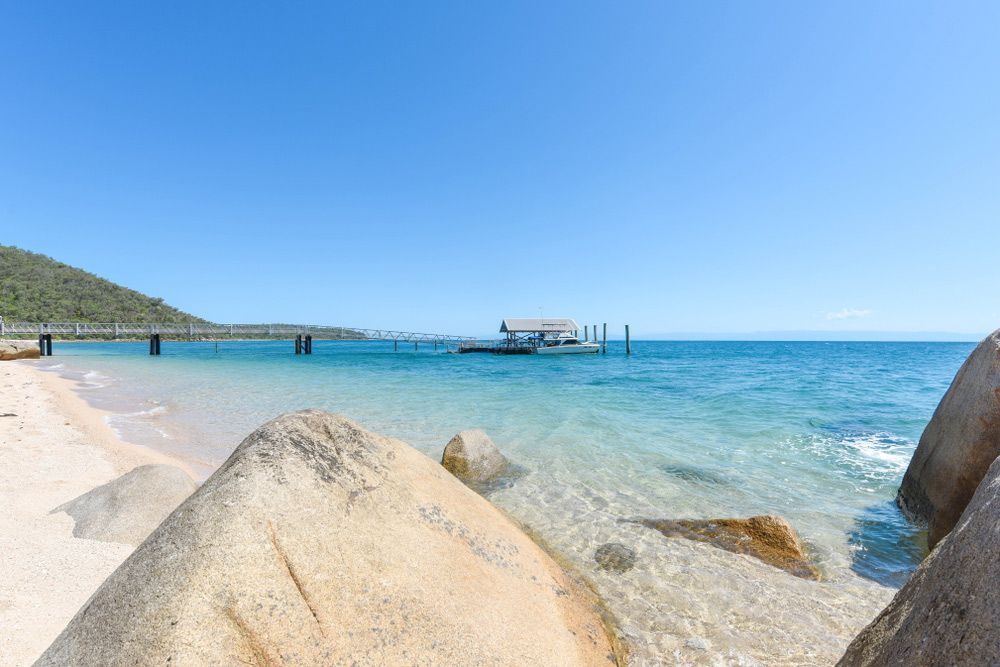 A Boat Is Docked at A Pier on A Beach — A M Conveyancing Pty Ltd In Palm Beach, QLD