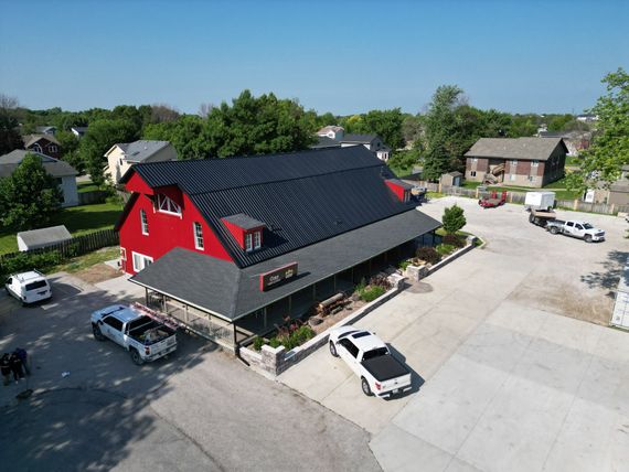 An aerial view of a red building with a black roof