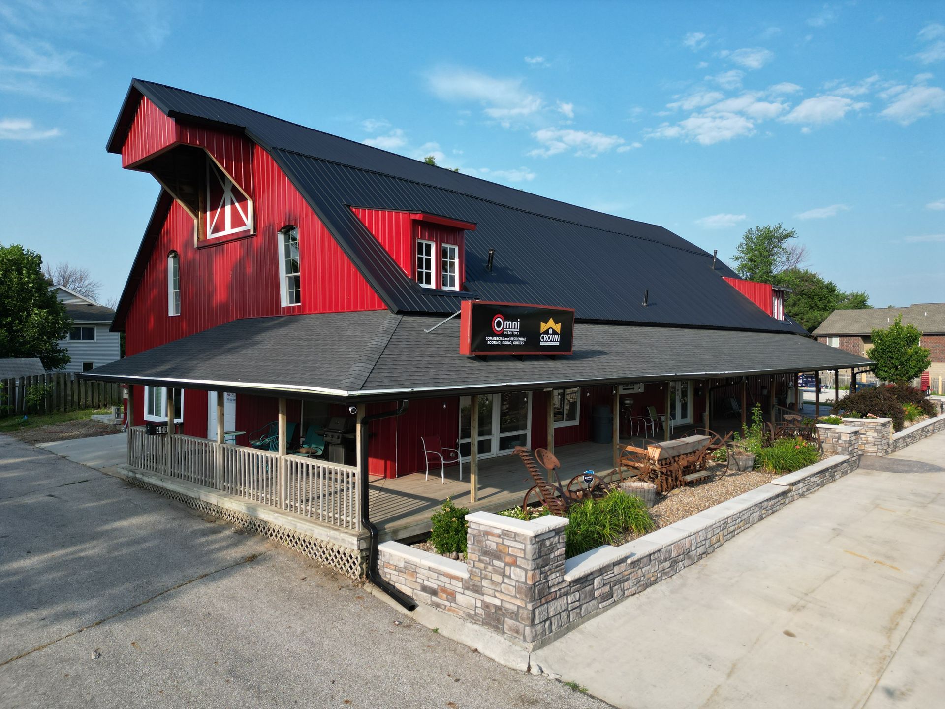 A large red barn with a black roof and a sign on the side of it.