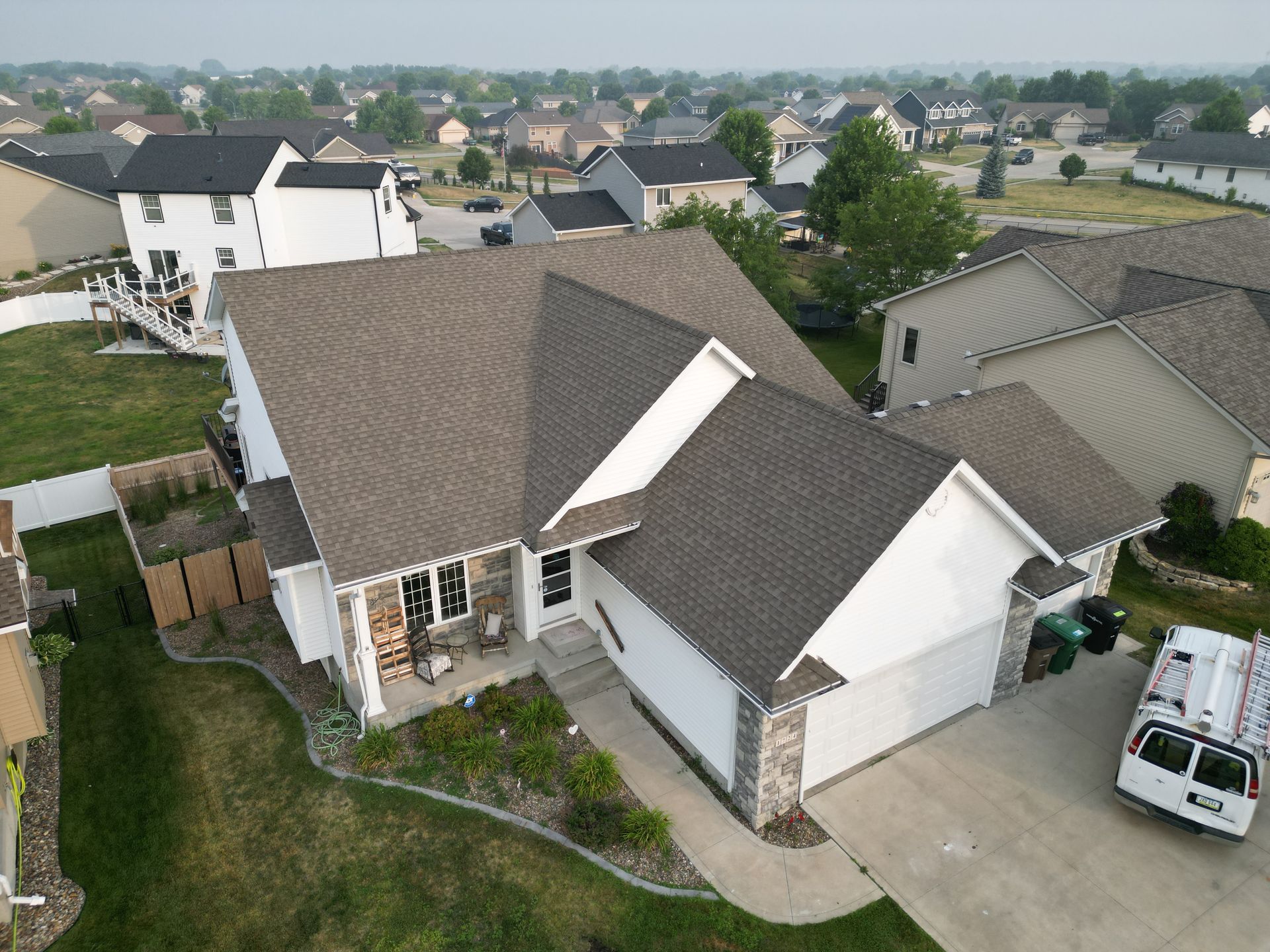 An aerial view of a house with a van parked in front of it.
