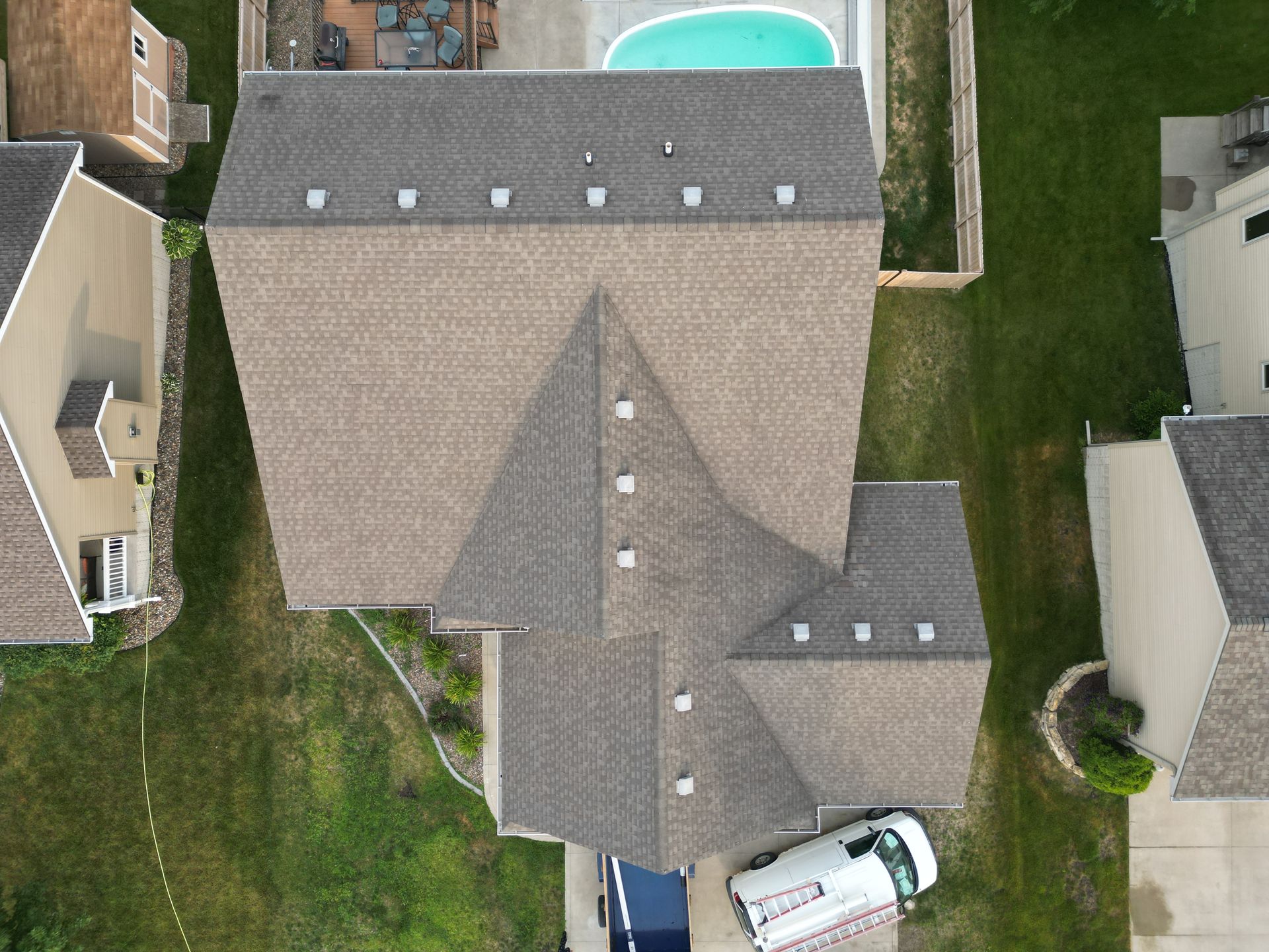 An aerial view of a house with a pool and a van parked in front of it.