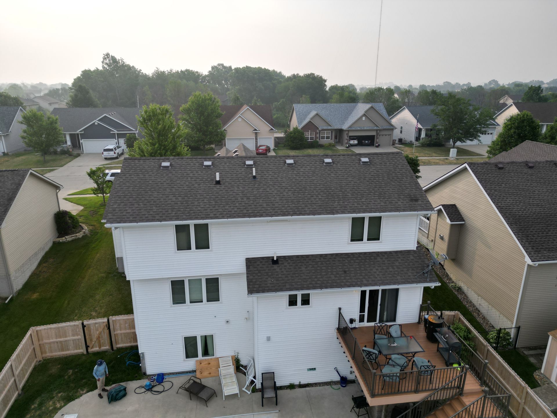 An aerial view of a house with a deck in the backyard