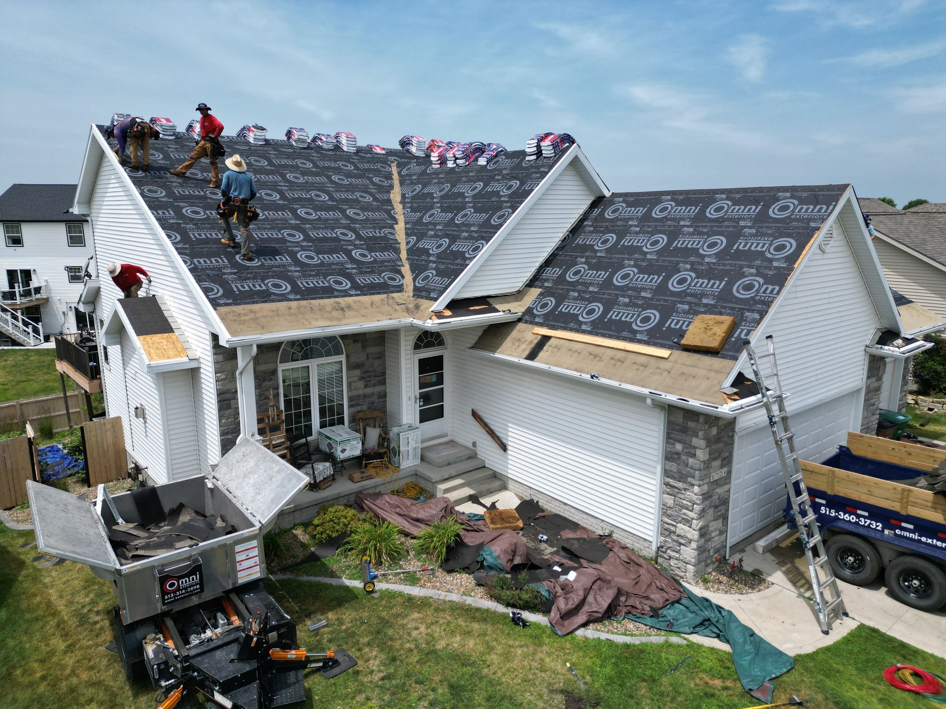 A group of people are working on the roof of a house.