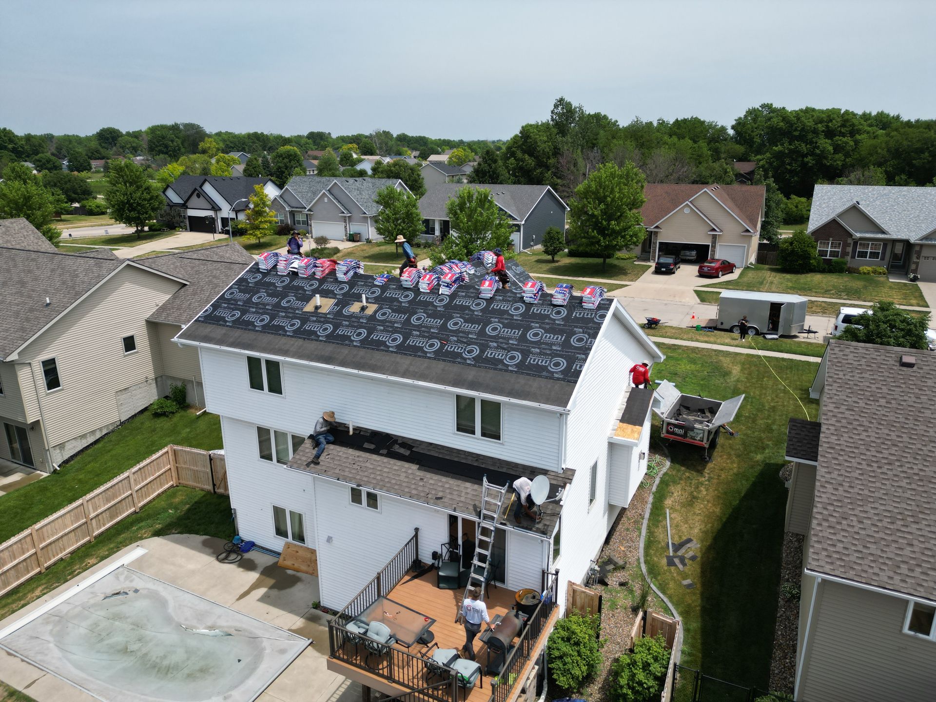 A group of people are working on the roof of a house.
