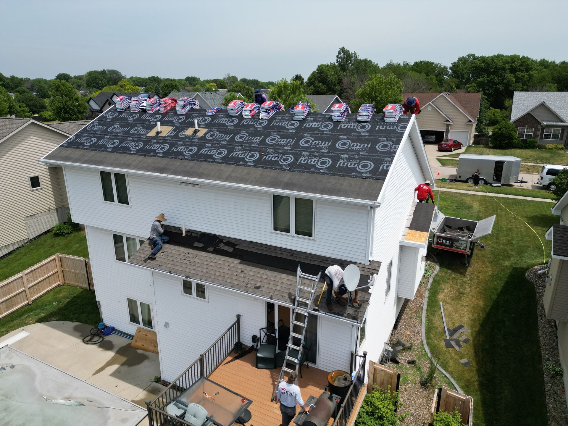 A group of people are working on the roof of a house.