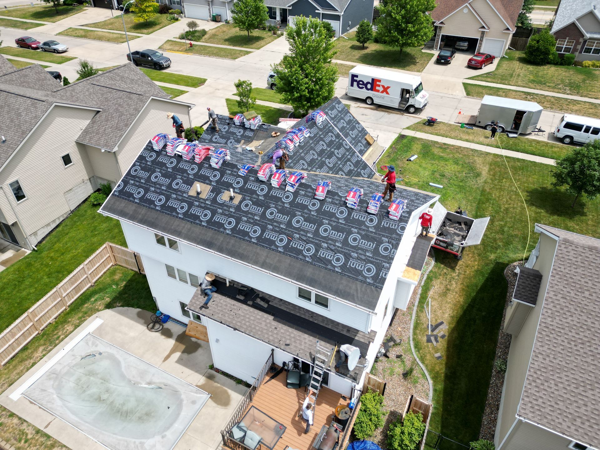 An aerial view of a house being remodeled with a fedex truck in the background.