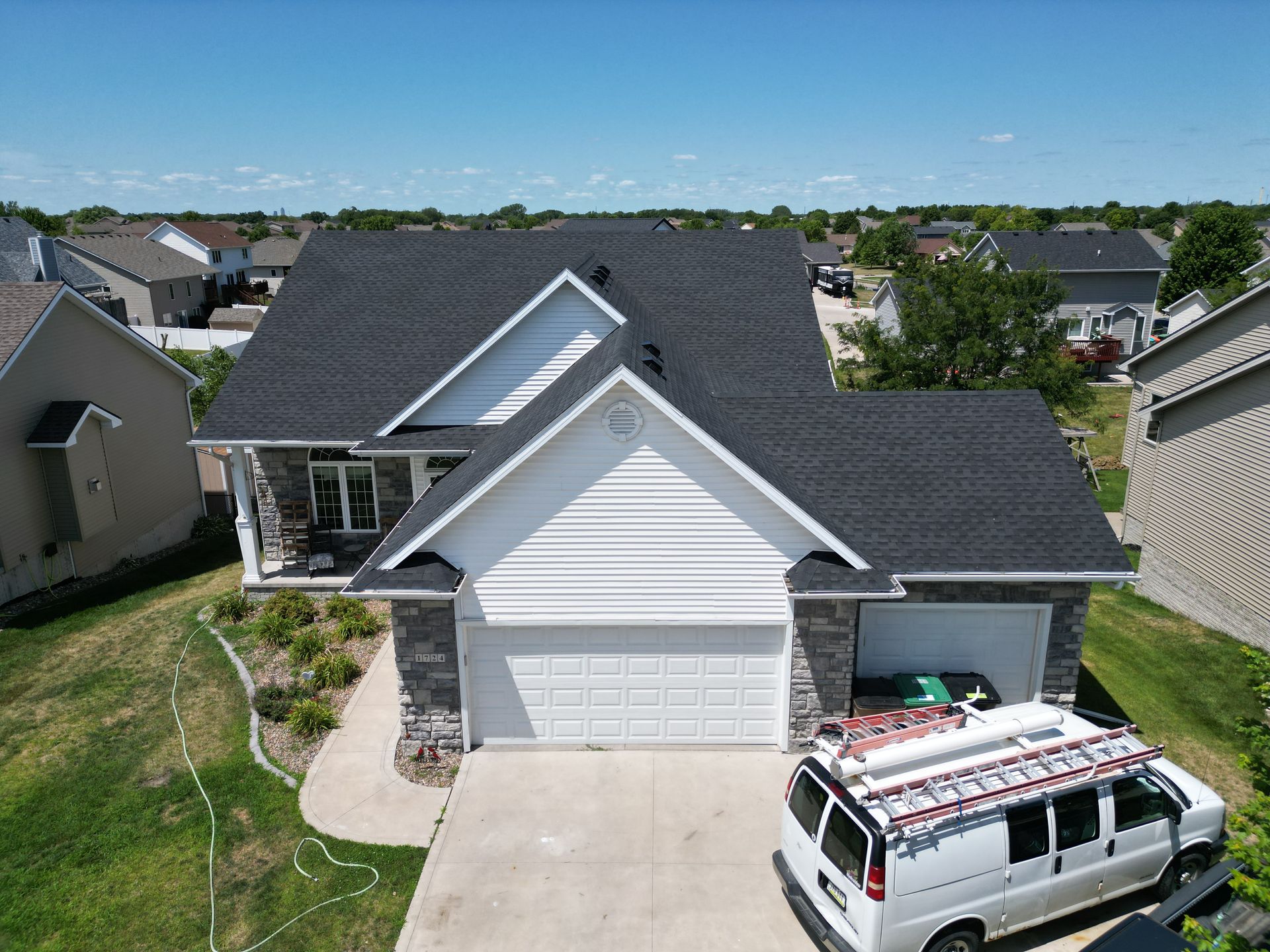 An aerial view of a house with a van parked in front of it.