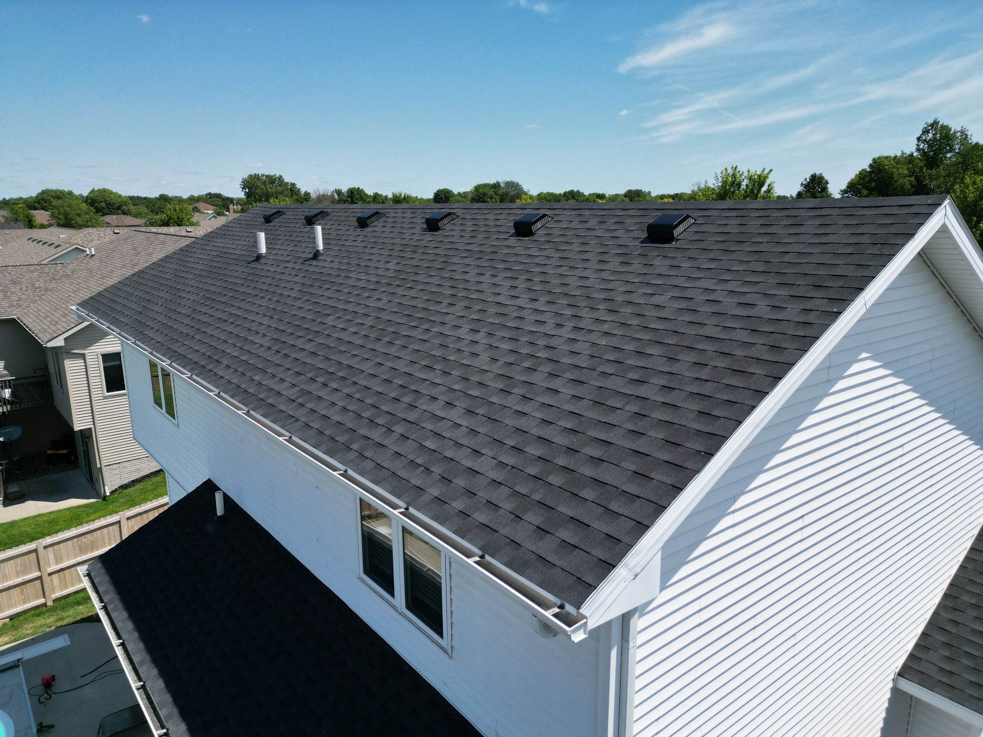 An aerial view of a house with a black roof.