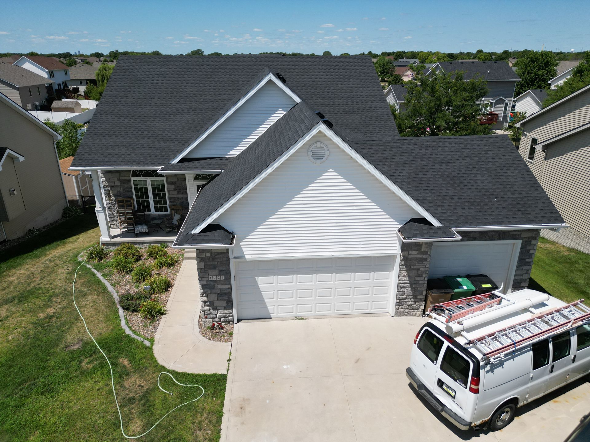 An aerial view of a house with a van parked in front of it.