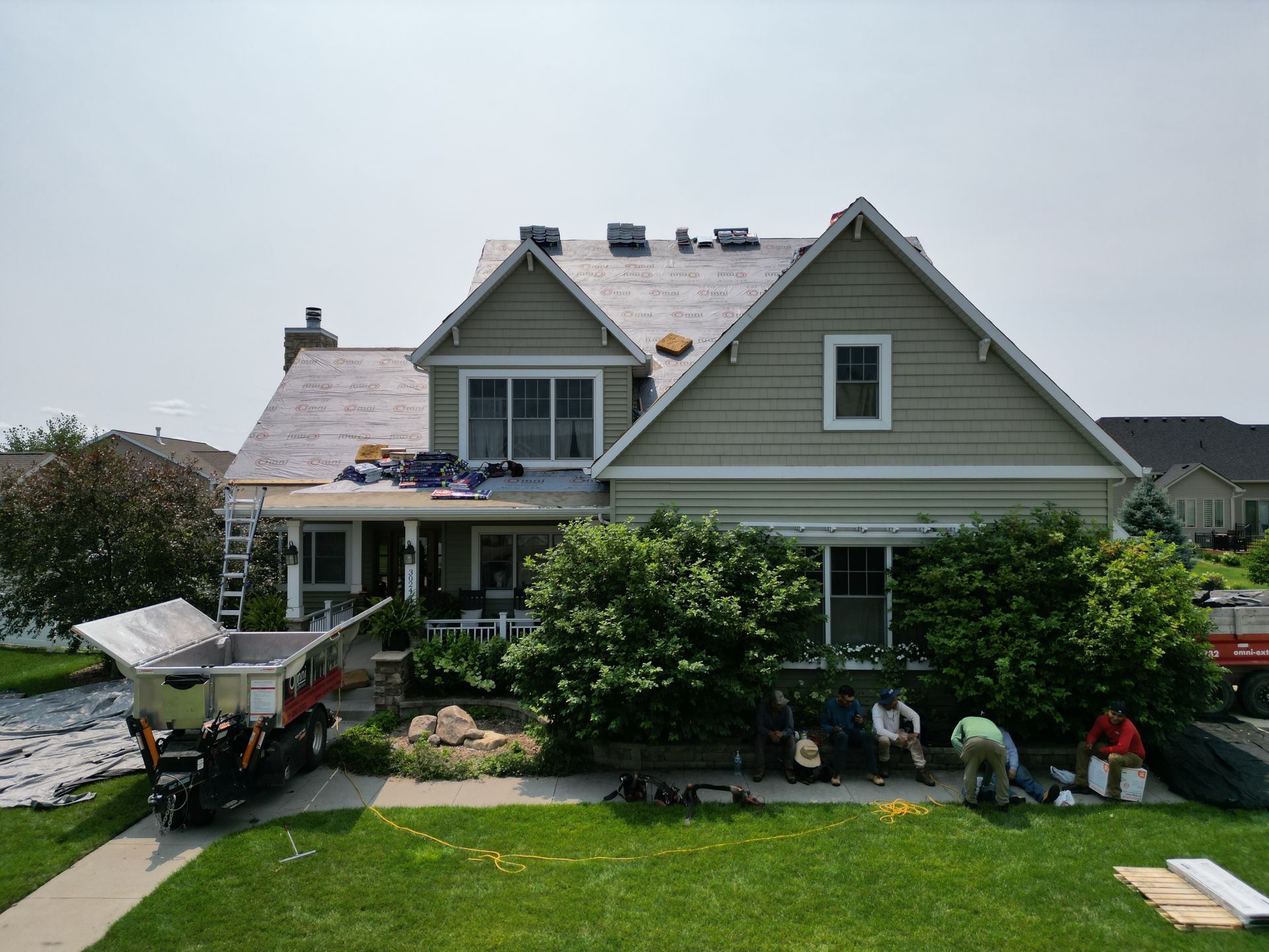 A house is being remodeled with a roof being installed