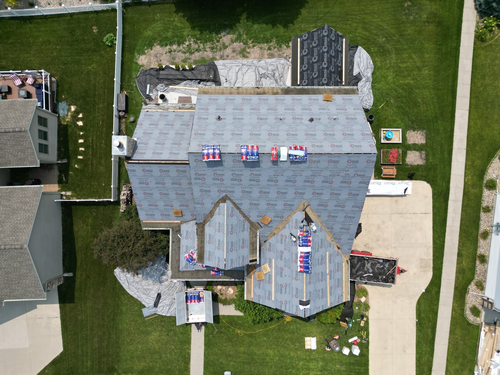 An aerial view of a house with a new roof being installed.