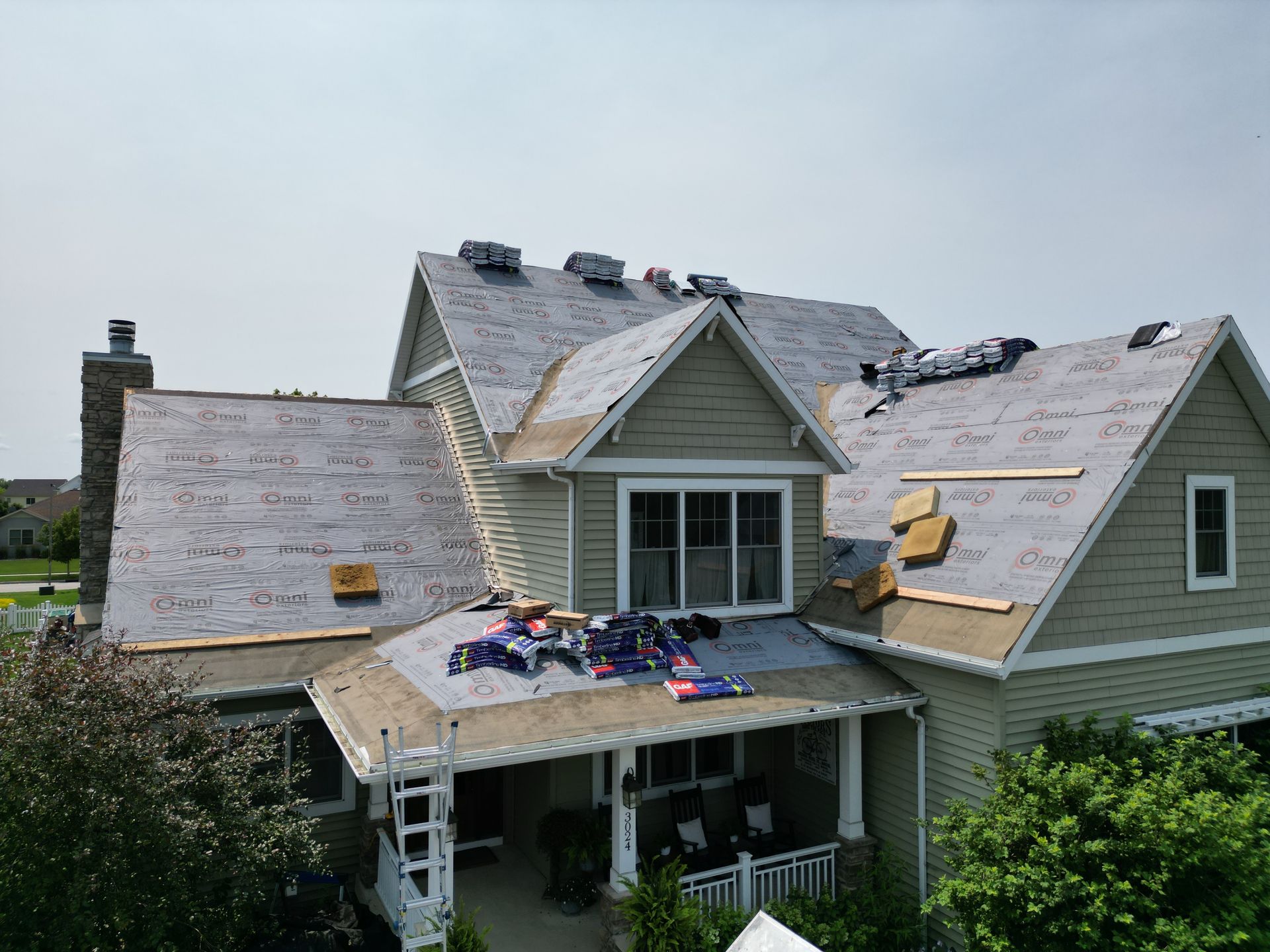 An aerial view of a house with a new roof being installed.