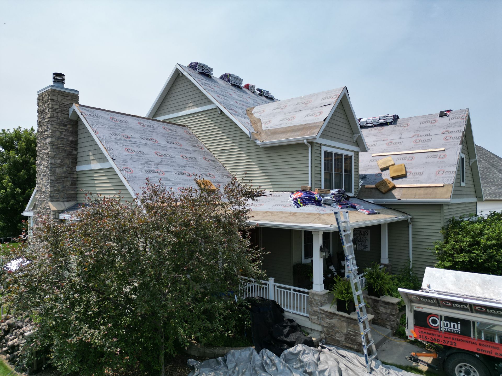 A large house is being remodeled with a roof being installed.