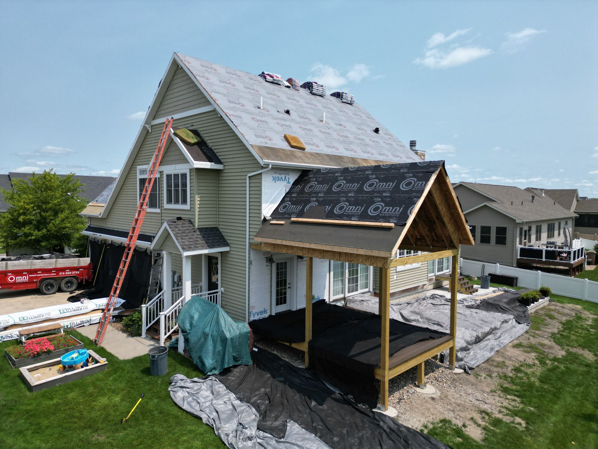 An aerial view of a house under construction with a roof being installed.