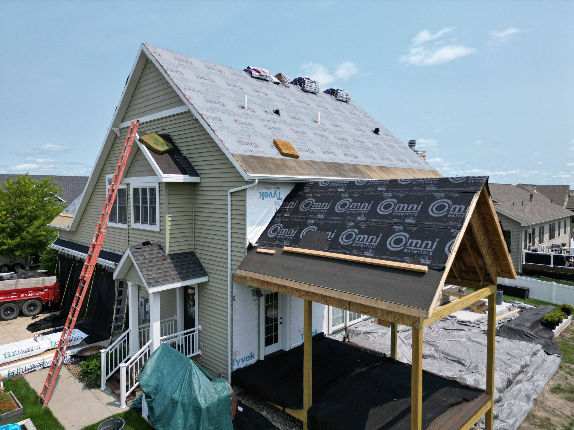 An aerial view of a house under construction with a roof being installed.