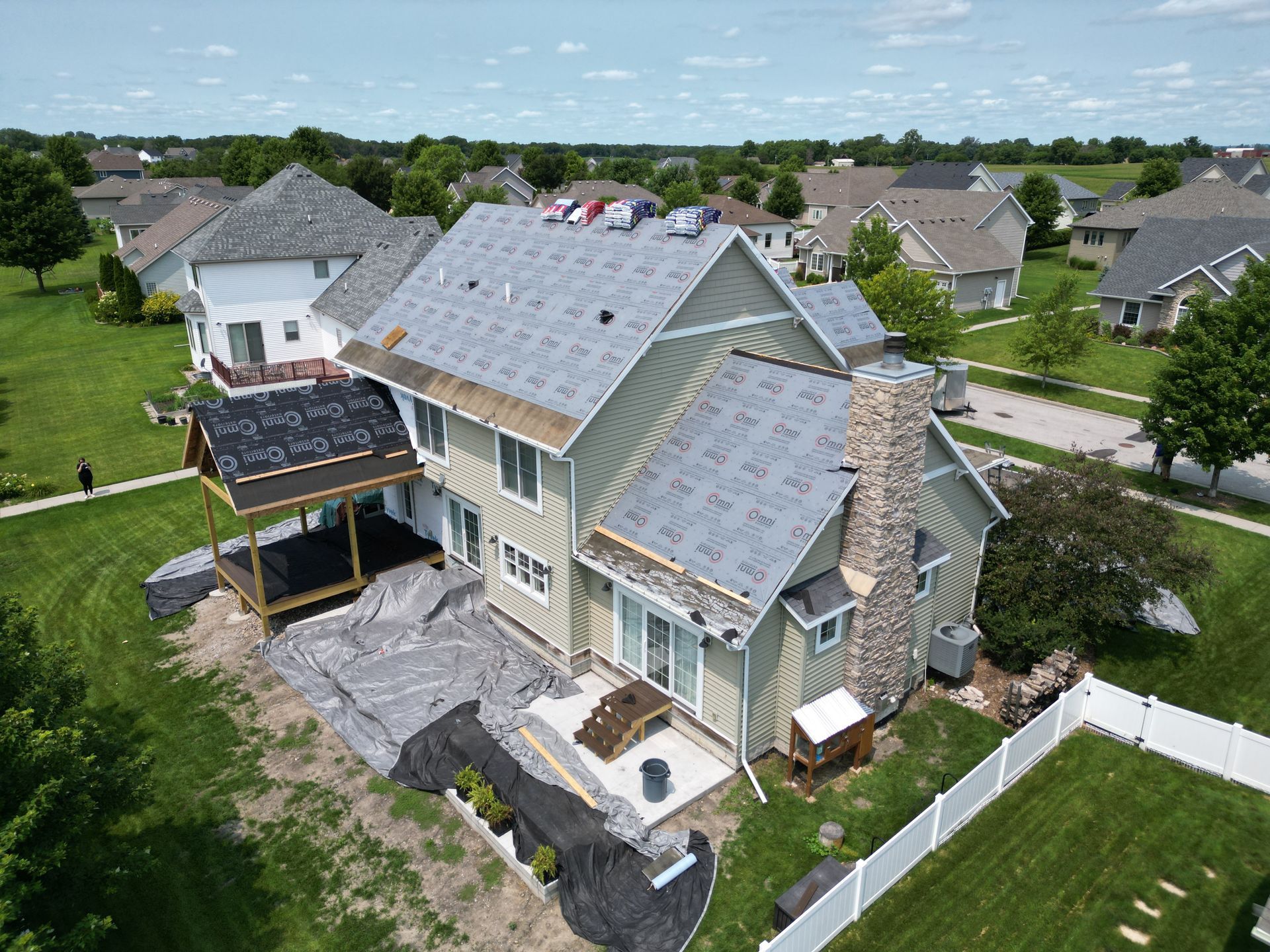 An aerial view of a house under construction in a residential area.