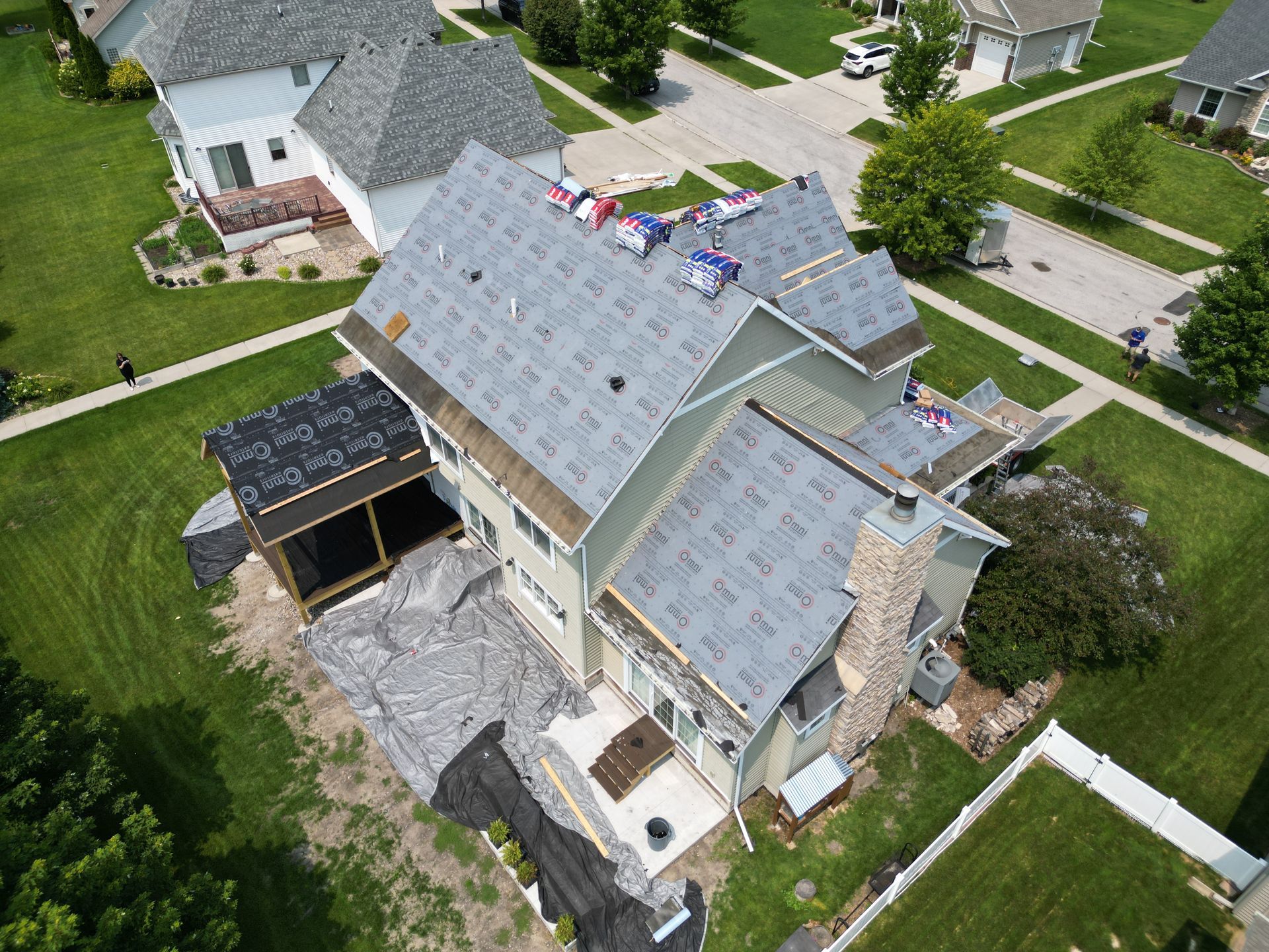 An aerial view of a house under construction in a residential neighborhood.